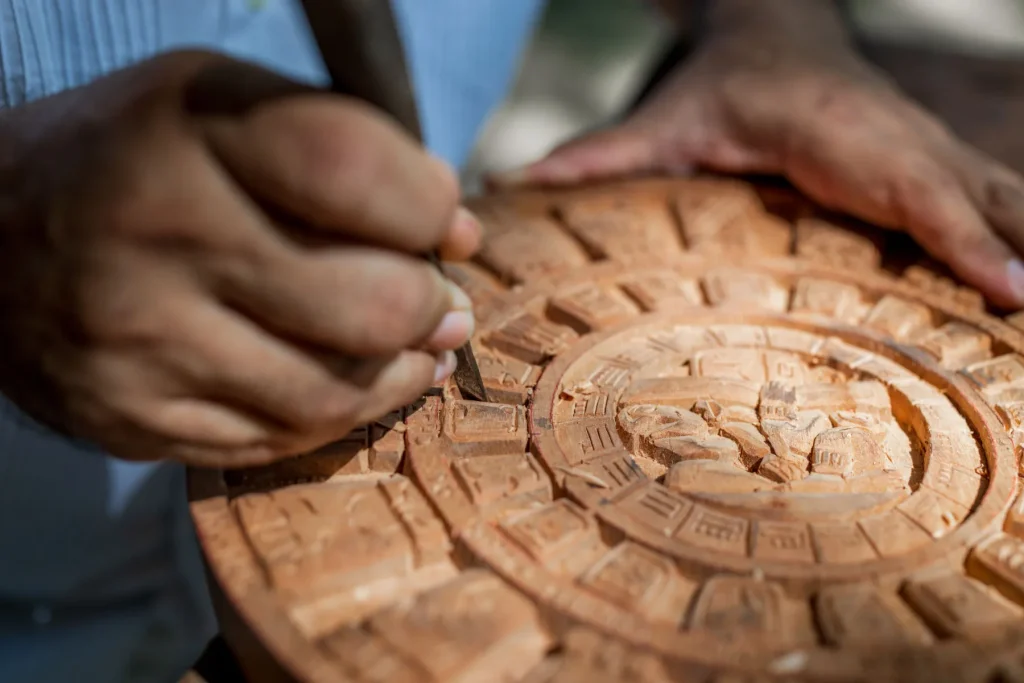Artisan carving a Mayan-inspired wooden piece at Xcaret